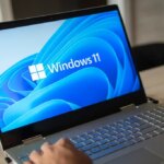 Man working on a Windows 11 laptop clearly on screen