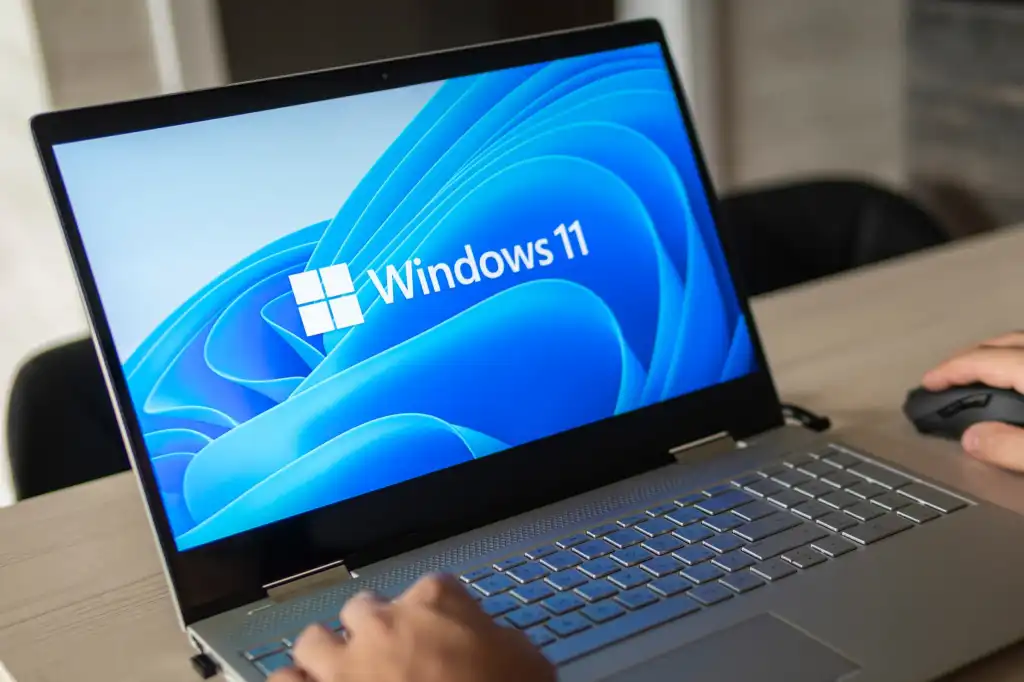 Man working on a Windows 11 laptop clearly on screen