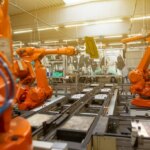 A factory with orange robotic arms.
