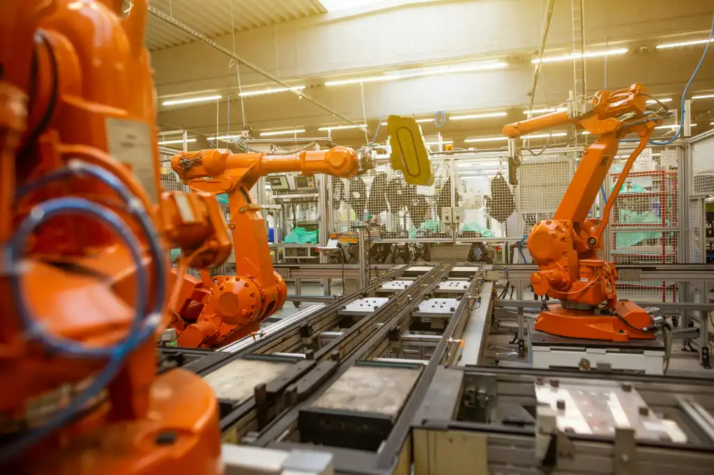 A factory with orange robotic arms.