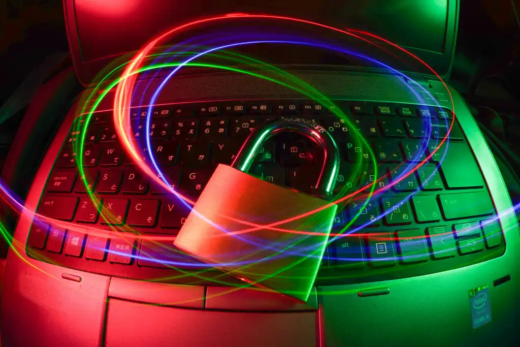 Colored lights over a padlock on top of a laptop computer. Indicates security.