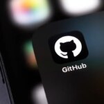 GitHub mobile icon app on a screen smartphone and notebook closeup. GitHub is the largest web service for hosting and developing IT projects. Batumi, Georgia - November 4, 2023