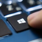 Finger-pressing-Windows-key-on-a-blue-laptop-keyboard