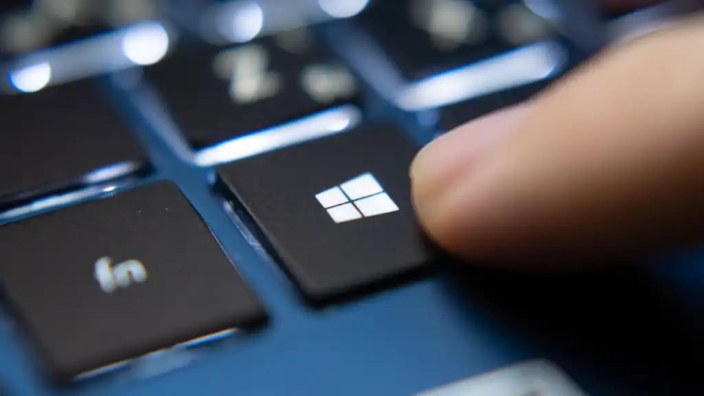 Finger-pressing-Windows-key-on-a-blue-laptop-keyboard