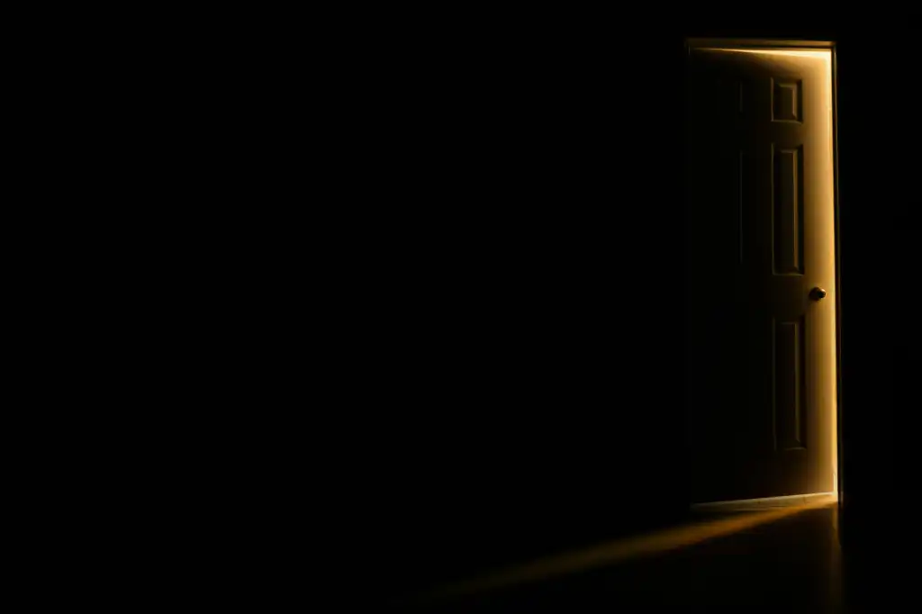 an open door in a dark room with light coming in