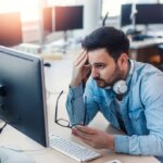 Handsome modern worried programmer working on project