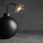shutterstock 1951501180 old fashioned bomb with lit fuse against gray background