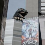 a tall building with a godzilla statue on top of it