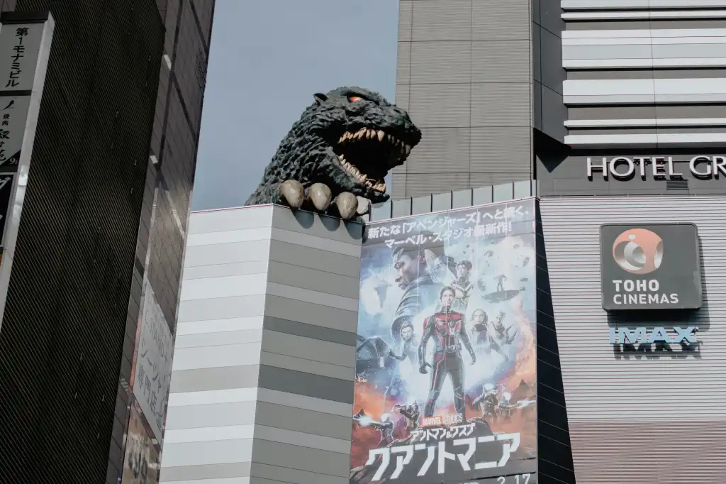 a tall building with a godzilla statue on top of it