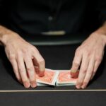 A picture of a poker dealer with the cards in his hand.