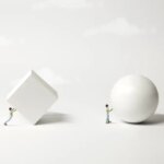 Surreal minimalist conceptual diagram of man pushing pushing block versus man pushing a ball. White objects against a gray background with white clouds. Hard way versus easy way. Evolution of ideas. Technology innovation. .