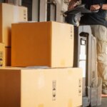 warehouse worker loading packages boxes for shipment at distribution center shipping dock