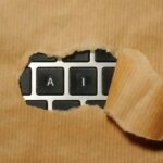 A piece of cardboard with AI on a keyboard appearing through it