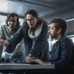 Team of Three Diverse South Asian Software Developers Talk, Discuss a Technological Project. Empowered Indian Female Specialists and Two Colleagues Work on Digital Software as a Service Business