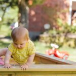baby trying to get out of his sandbox