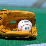 A picture of a baseball glove and an MLB baseball