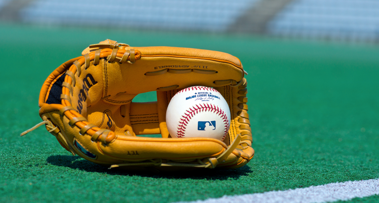 A picture of a baseball glove and an MLB baseball