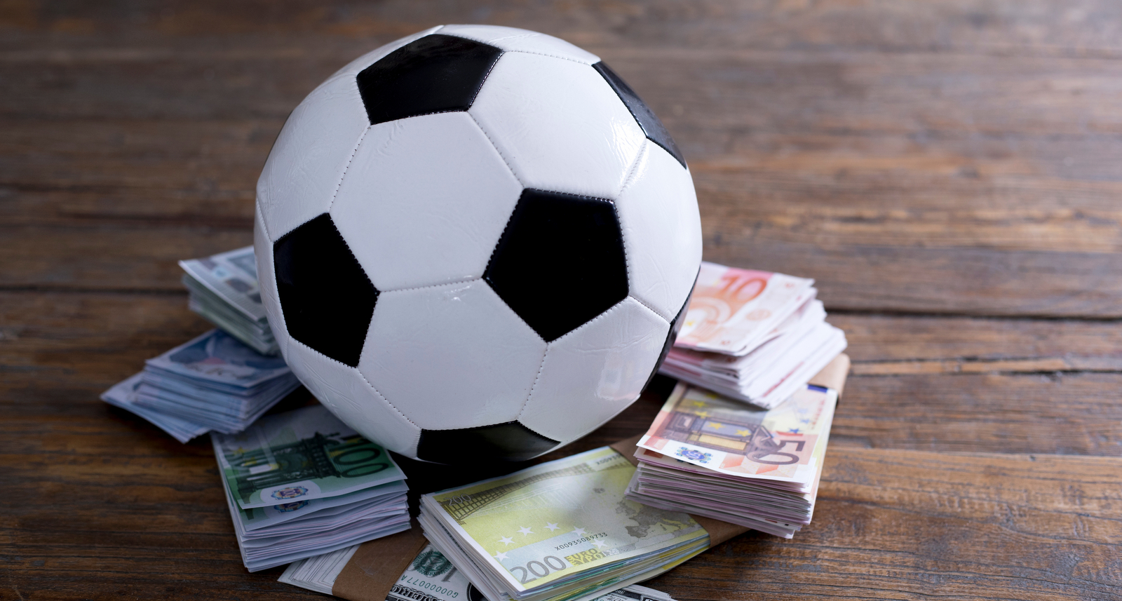 Une photo d'un ballon de football avec de l'argent en dessous