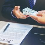 A picture of a banker handing over money for a loan