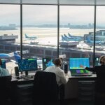 Diverse Air Traffic Control Team Working in a Modern Airport Tower. Office Room is Full of Desktop Computer Displays with Navigation Screens, Airplane Departure and Arrival Data for Controllers.