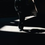 Man walking in shadows at bottom of stairs, visualizing a shadow AI agent