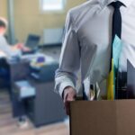 A picture of an office worker taking his personal belongings out of the office