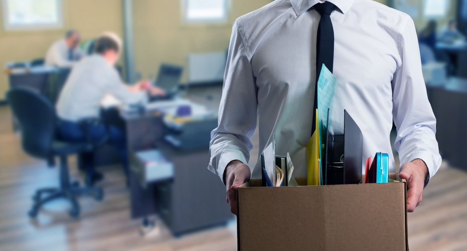 A picture of an office worker taking his personal belongings out of the office