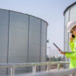 Asian male industrial engineer work through a laptop to Quality inspection in the engineering industry Utilities, water pipes and sewage pipes