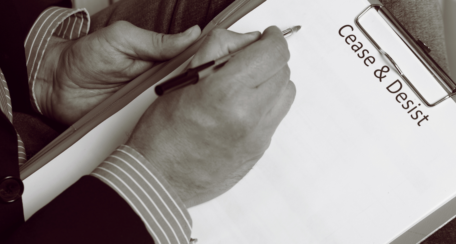 A picture of a man writing a cease & desist letter