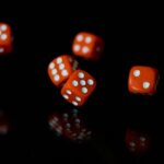 Red and white dice on a black background.