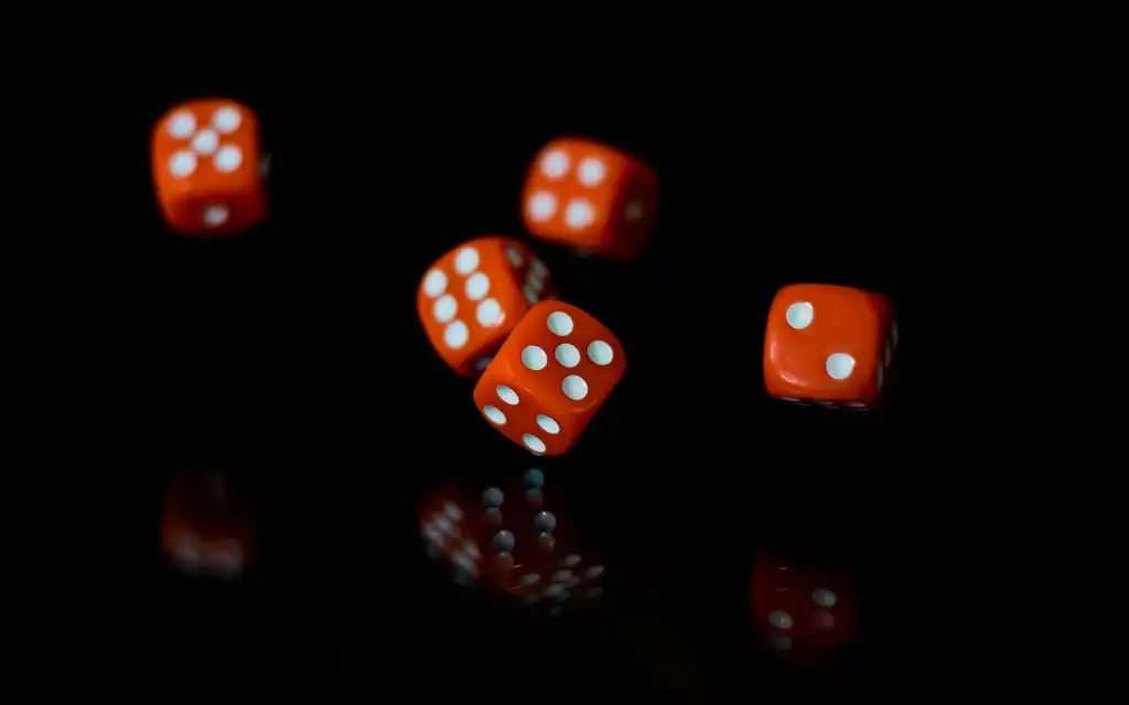 Red and white dice on a black background.