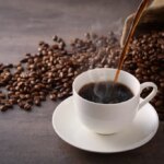shutterstock 560673883 coffee poured into white coffee cup coffee beans java