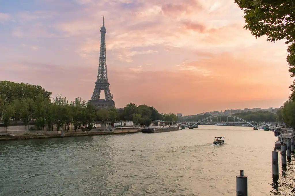 Eiffel Tower over the Seine river at sunset.
