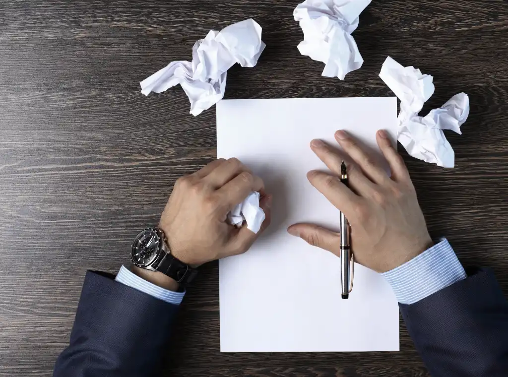 Close-up of male hands with pen over document crumpled paper
